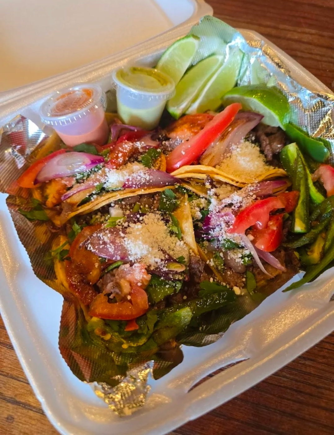Fajita tacos with cotija cheese, grilled peppers and limes